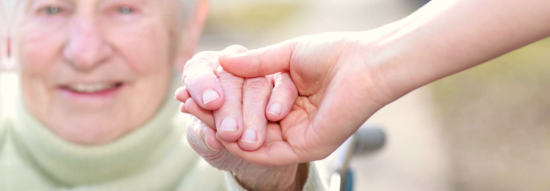 caregiver holding the hand of an elder