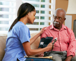 caregiver taking patients blood pressure